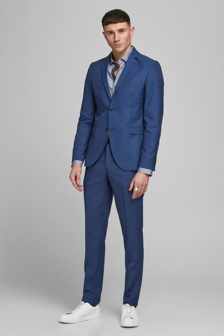 Blazer bleu de PREMIUM by JACK & JONES, porté avec une chemise à motifs et des baskets blanches.
