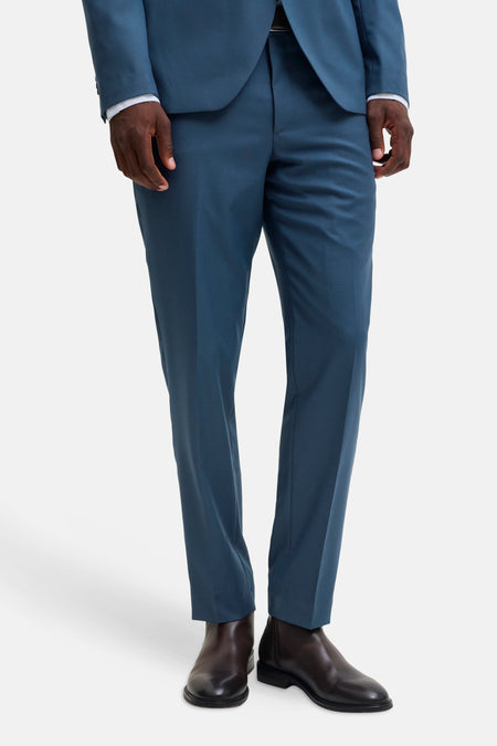 Blue tailored suit pants by JACK & JONES, slim fit with clean front crease, worn with matching blazer and dark brown leather boots, front view.
