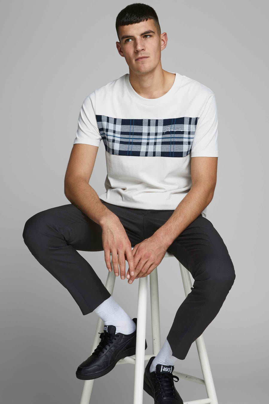 Pantalon de costume noir de PREMIUM by JACK & JONES, porté avec un t-shirt à carreaux et des baskets noires.