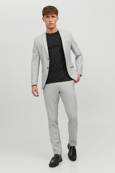 Pantalon de costume gris de PREMIUM BY JACK & JONES, porté avec un t-shirt noir et des mocassins noirs.