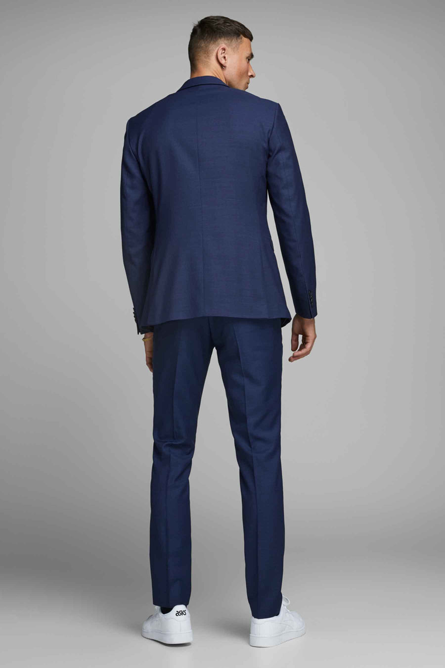 Blauwe kostuumbroek van PREMIUM by JACK & JONES, gedragen met witte sneakers.