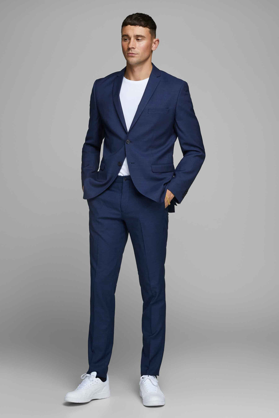 Blauwe pantalon van PREMIUM by JACK & JONES, gedragen met een wit T-shirt en witte sneakers.