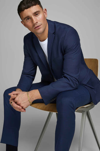 Blauwe pantalon van PREMIUM by JACK & JONES, gedragen met een wit T-shirt en gouden accessoires.