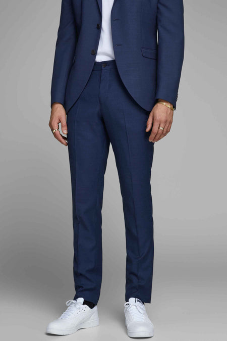 Pantalon de costume bleu de PREMIUM by JACK & JONES, coupe ajustée, porté avec des baskets blanches.
