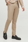 Pantalon de costume beige, de PREMIUM BY JACK & JONES, porté avec des mocassins noirs, en position debout.
