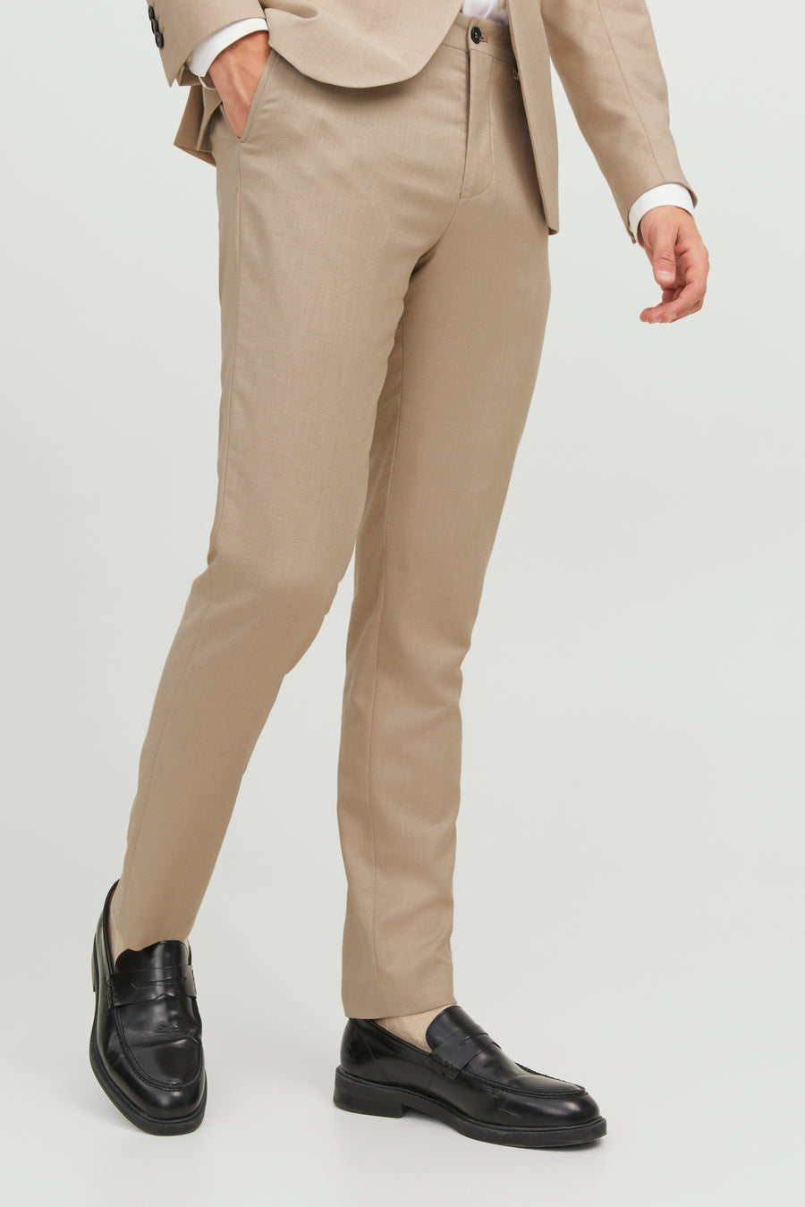 Pantalon de costume beige, de PREMIUM BY JACK & JONES, porté avec des mocassins noirs, en position debout.