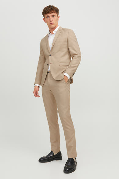 Pantalon de costume beige par PREMIUM BY JACK & JONES, coupe ajustée, porté avec veste assortie et chaussures noires.
