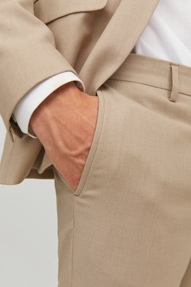 Pantalon de costume beige de Premium by Jack & Jones, avec une main dans la poche.