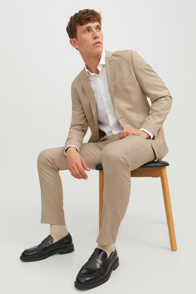 Pantalon de costume beige de PREMIUM BY JACK & JONES porté avec une chemise blanche et des mocassins noirs.