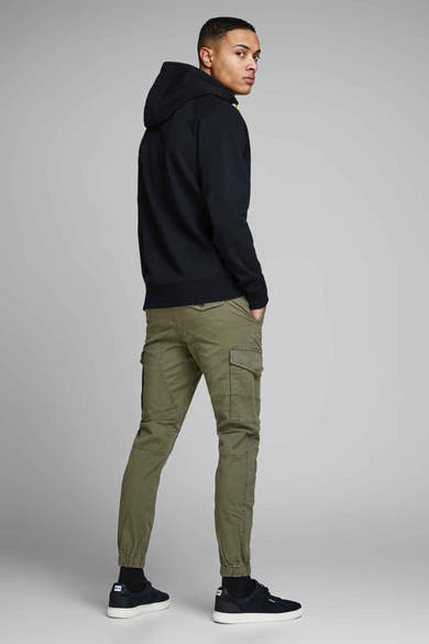 Pantalon cargo vert olive de JACK & JONES JEANS INTELLIGENCE, porté avec un sweat à capuche noir et des chaussures de sport noires et blanches.