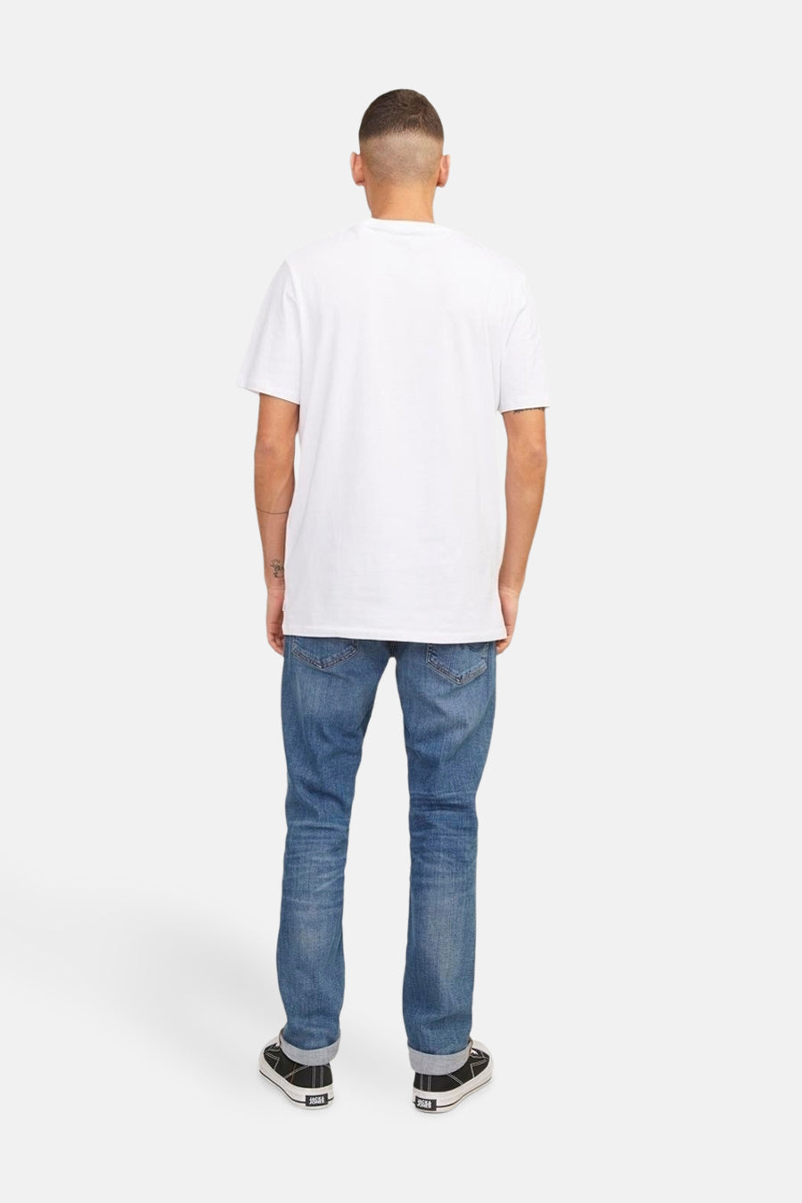 Middelblauwe slim fit jeans van JACK & JONES JEANS INTELLIGENCE, gedragen met een wit T-shirt en zwarte schoenen.