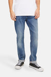 Slim fit jeans in medium blue denim van JACK & JONES JEANS INTELLIGENCE, gedragen met zwart-witte sneakers.