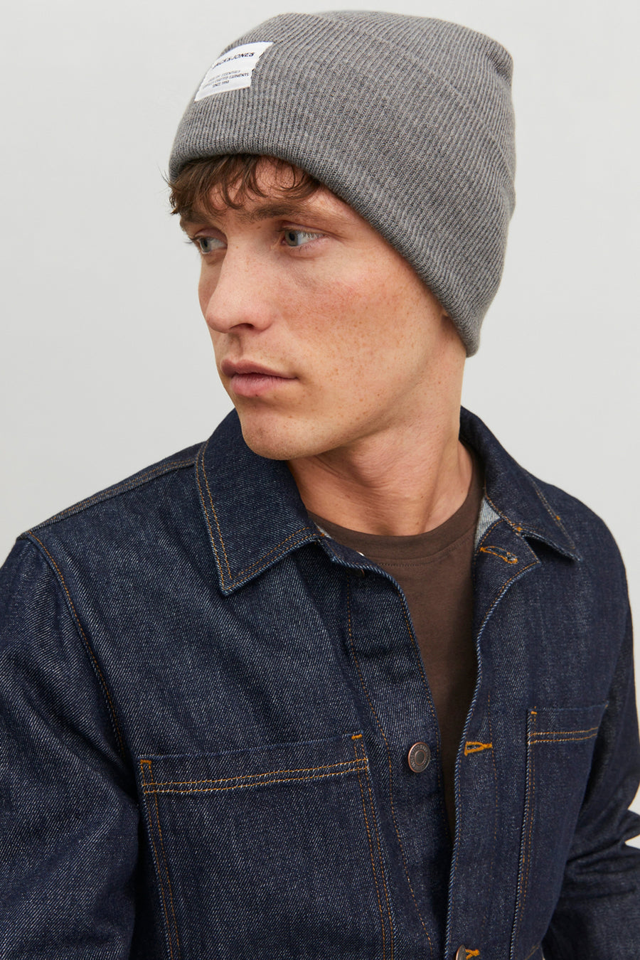 Grijze gebreide muts van ACCESSORIES BY JACK & JONES, gedragen met een indigoblauwe spijkerjas.