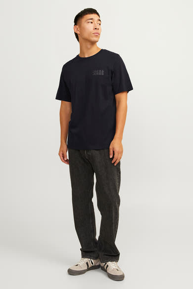 T-shirt à manches courtes noir de JACK & JONES, porté avec un pantalon noir délavé et des baskets.