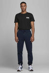 Zwart T-shirt met korte mouwen van JACK & JONES, gedragen met een marineblauwe joggingbroek en sportschoenen.