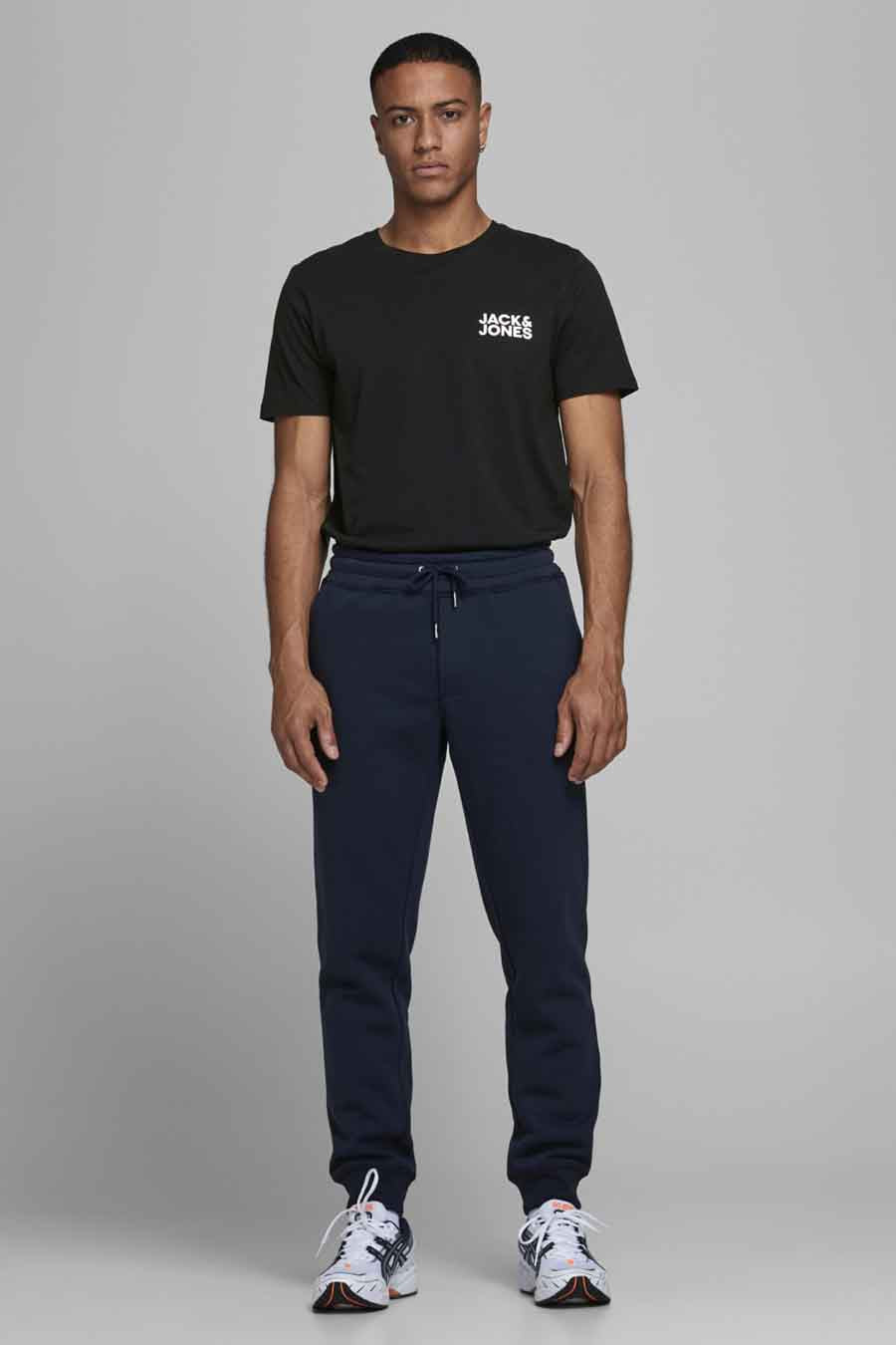Zwart T-shirt met korte mouwen van JACK & JONES, gedragen met een marineblauwe joggingbroek en sportschoenen.
