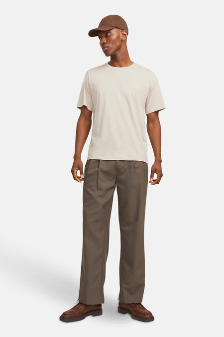 Beige T-shirt met korte mouwen van JACK & JONES, gedragen met een bruine broek en leren schoenen.