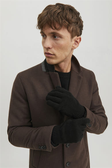 Gants noirs en tricot d'ACCESSORIES BY JACK & JONES, portés avec un manteau marron et un pull noir.
