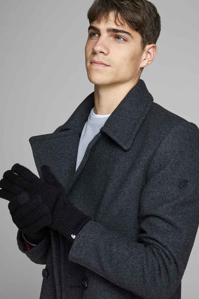 Gants noirs par ACCESSORIES BY JACK & JONES, tricotés avec logo discret, portés avec un manteau en laine.
