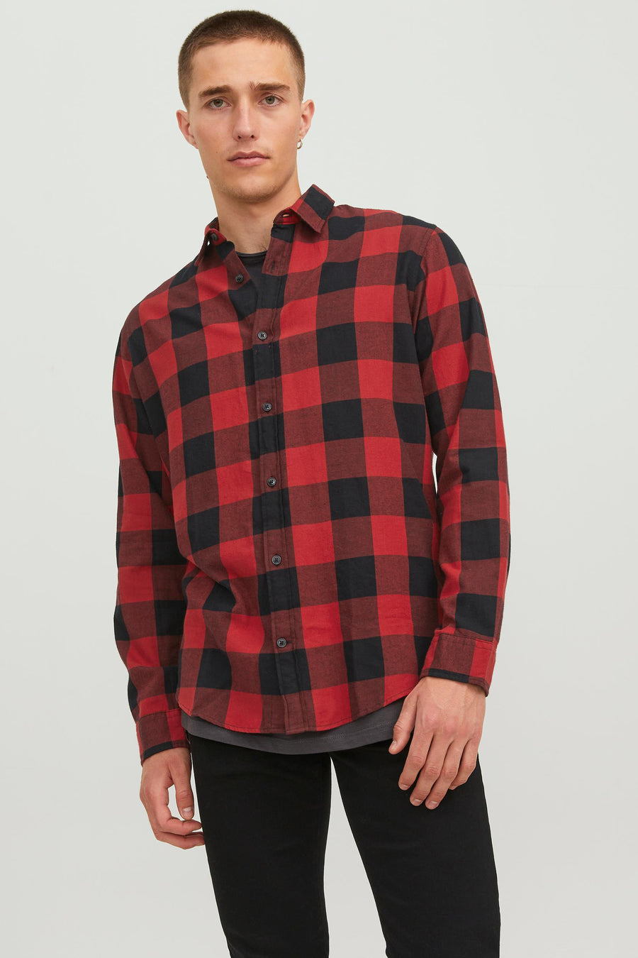 Rood-zwart geruit overhemd met lange mouwen van JACK & JONES gedragen over een grijs T-shirt, met een zwarte broek.