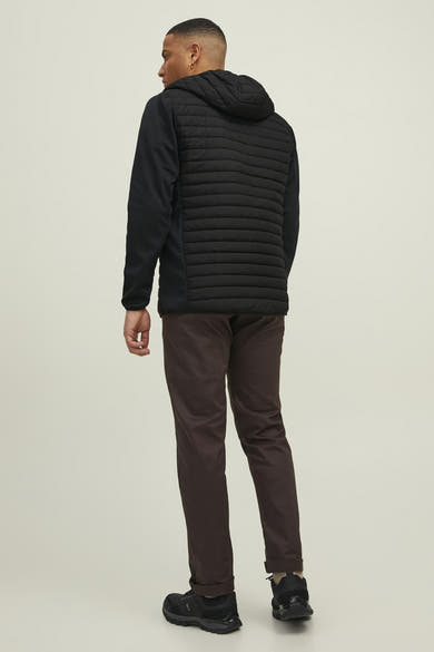 Zwarte regenjas van JACK & JONES, achterkant, met capuchon en bruine broek.