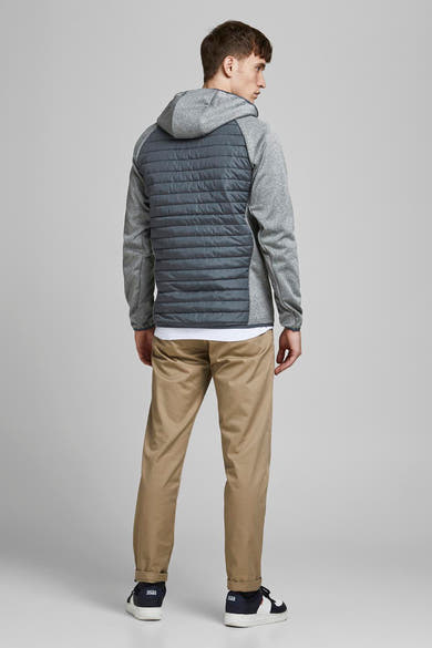 Grijze waterdichte jas van JACK & JONES, met capuchon en gewatteerd rugpaneel, gedragen met een kaki broek.