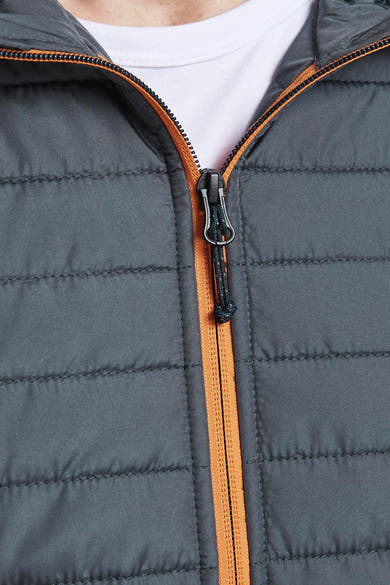 Veste imperméable grise de JACK & JONES avec fermeture éclair orange et texture matelassée.