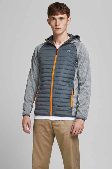 Veste imperméable grise par JACK & JONES avec fermeture éclair orange sur un modèle portant un pantalon beige.
