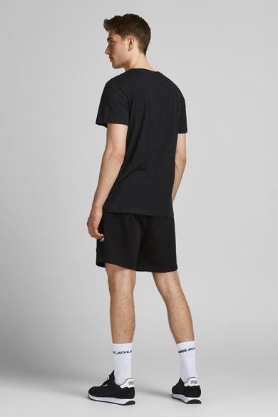 Korte zwarte broek van JACK & JONES JEANS INTELLIGENCE, gedragen met een zwart T-shirt, witte sokken en zwart-witte sneakers.