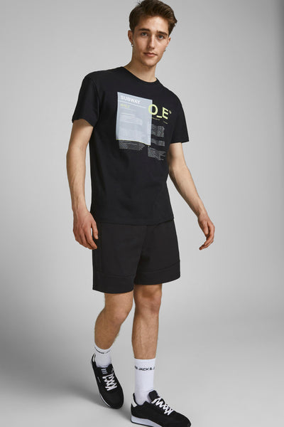 Korte jeans van JACK & JONES JEANS INTELLIGENCE, gedragen met een T-shirt met print en bijpassende sneakers.