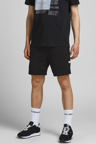 Short noir de JACK & JONES, porté avec un t-shirt noir imprimé et des chaussures de sport noires.
