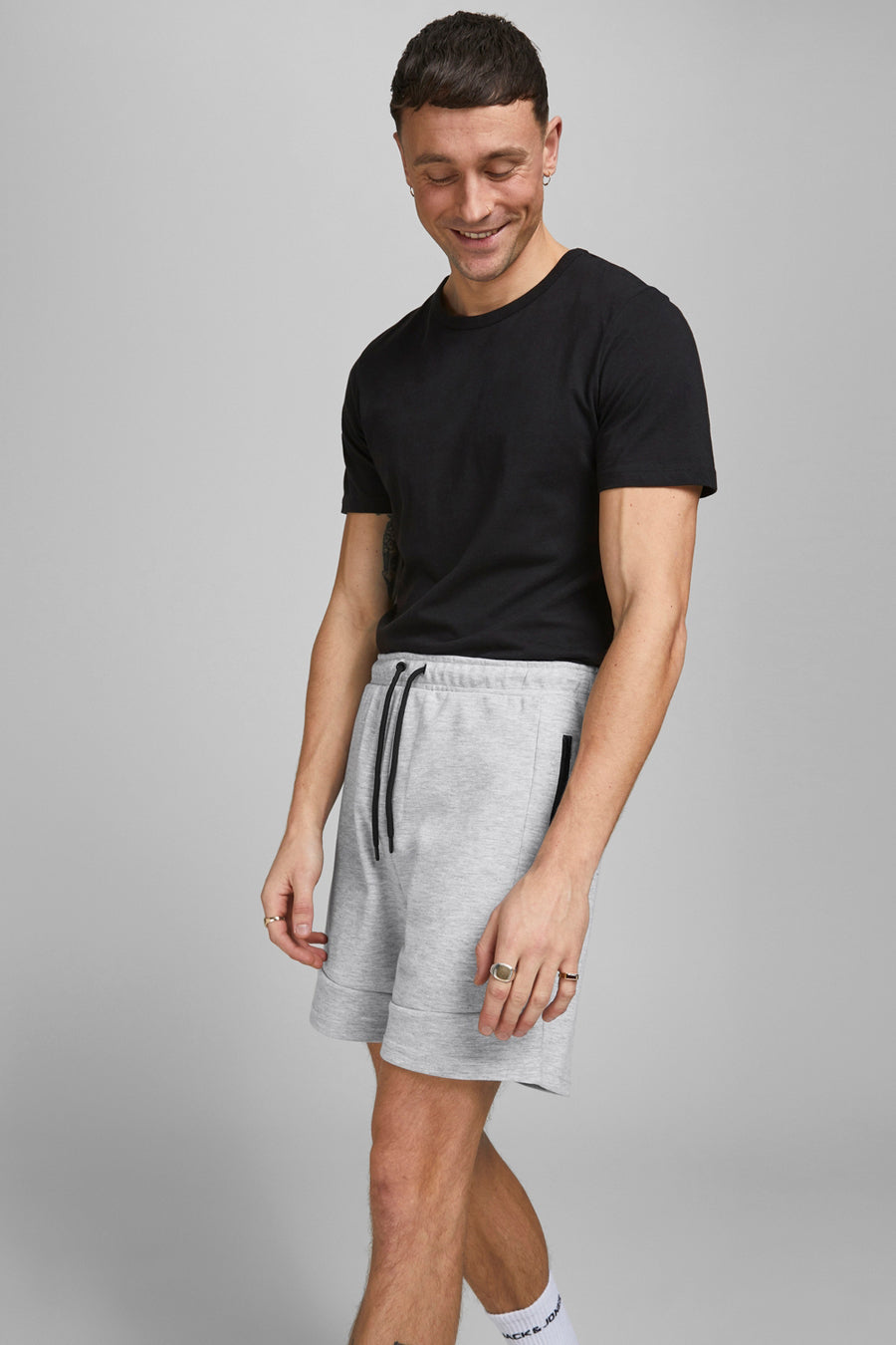 Kort grijs gemêleerd short van JACK & JONES JEANS INTELLIGENCE, met trekkoord en biesafwerking, gedragen met een zwart T-shirt.