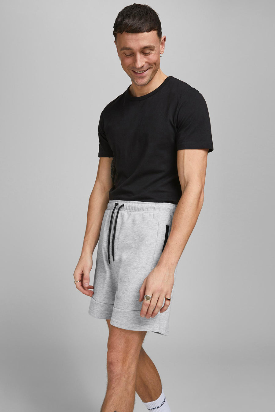Korte grijze short van JACK & JONES JEANS INTELLIGENCE, met trekkoord en ritszakken, gedragen met een zwart T-shirt.