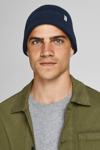 Bonnet bleu par ACCESSORIES BY JACK & JONES, en maille côtelée, porté avec un t-shirt gris et une surchemise kaki.
