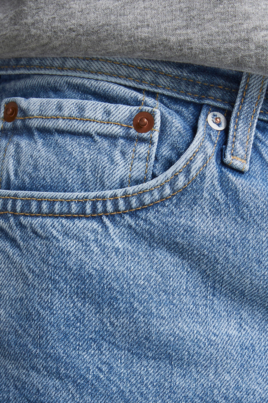 Jean fuselé CHRIS bleu clair de JACK & JONES JEANS INTELLIGENCE, avec poche avant, rivets cuivrés, coutures contrastées et aspect usé.