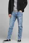 Jeans tapered en denim bleu clair de JACK & JONES JEANS INTELLIGENCE, portés avec des baskets et une veste noire.
