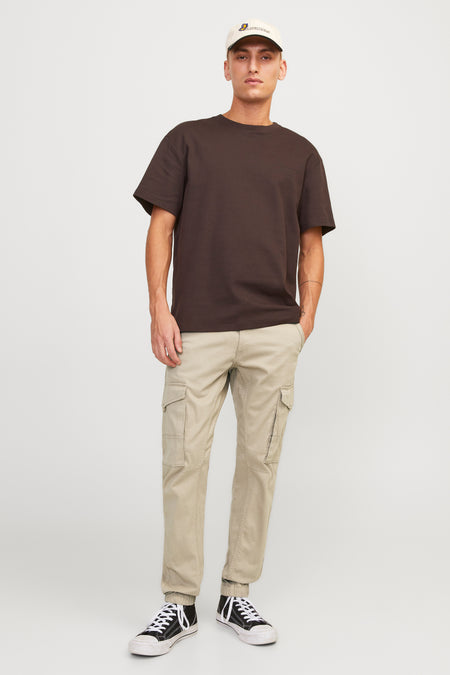 Pantalon cargo beige de JACK & JONES JEANS INTELLIGENCE avec poches latérales et chaussures noires.
