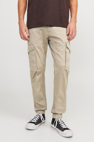Pantalon cargo beige de JACK & JONES JEANS INTELLIGENCE, porté avec un t-shirt marron et des baskets noires et blanches.
