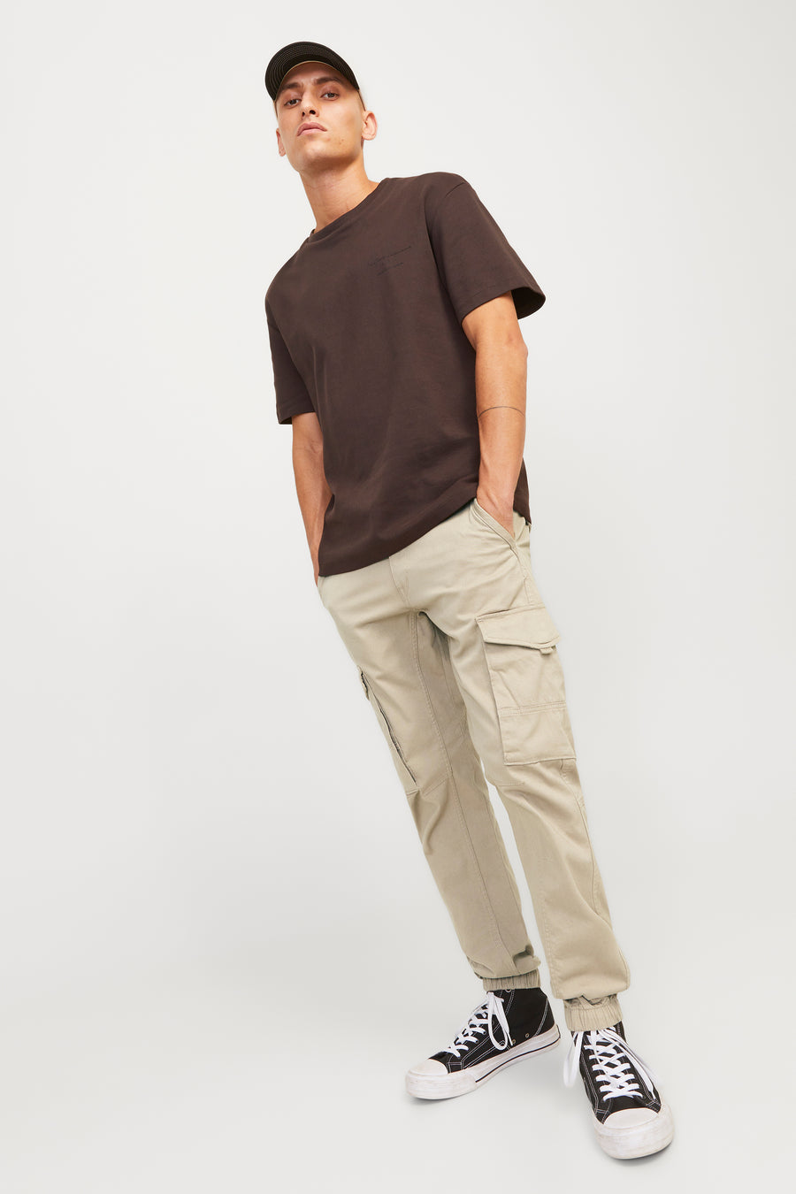 Pantalon cargo beige de JACK & JONES JEANS INTELLIGENCE, porté avec un t-shirt brun et des baskets noires.