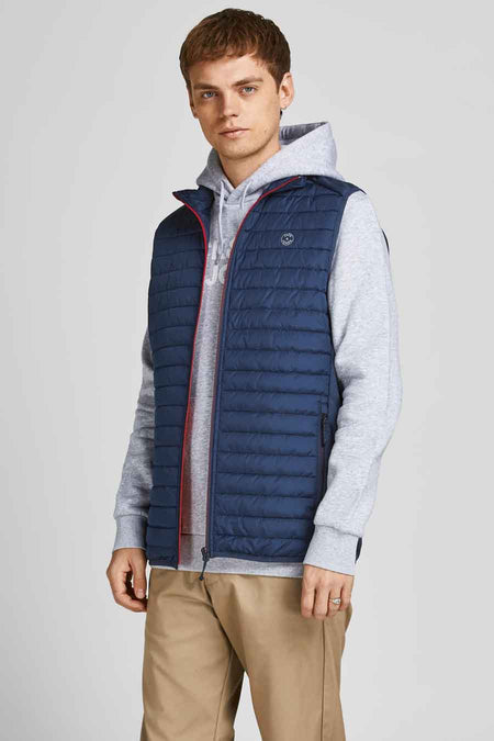 Veste sans manches bleue de JACK & JONES, portée par-dessus un sweat à capuche gris et un pantalon kaki.
