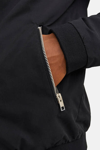 Korte zwarte jas van JACK & JONES met zilveren ritssluiting en geribbelde manchetten.