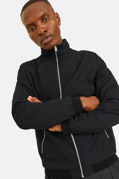Korte zwarte jas van JACK & JONES met zilveren ritssluiting en opstaande kraag.