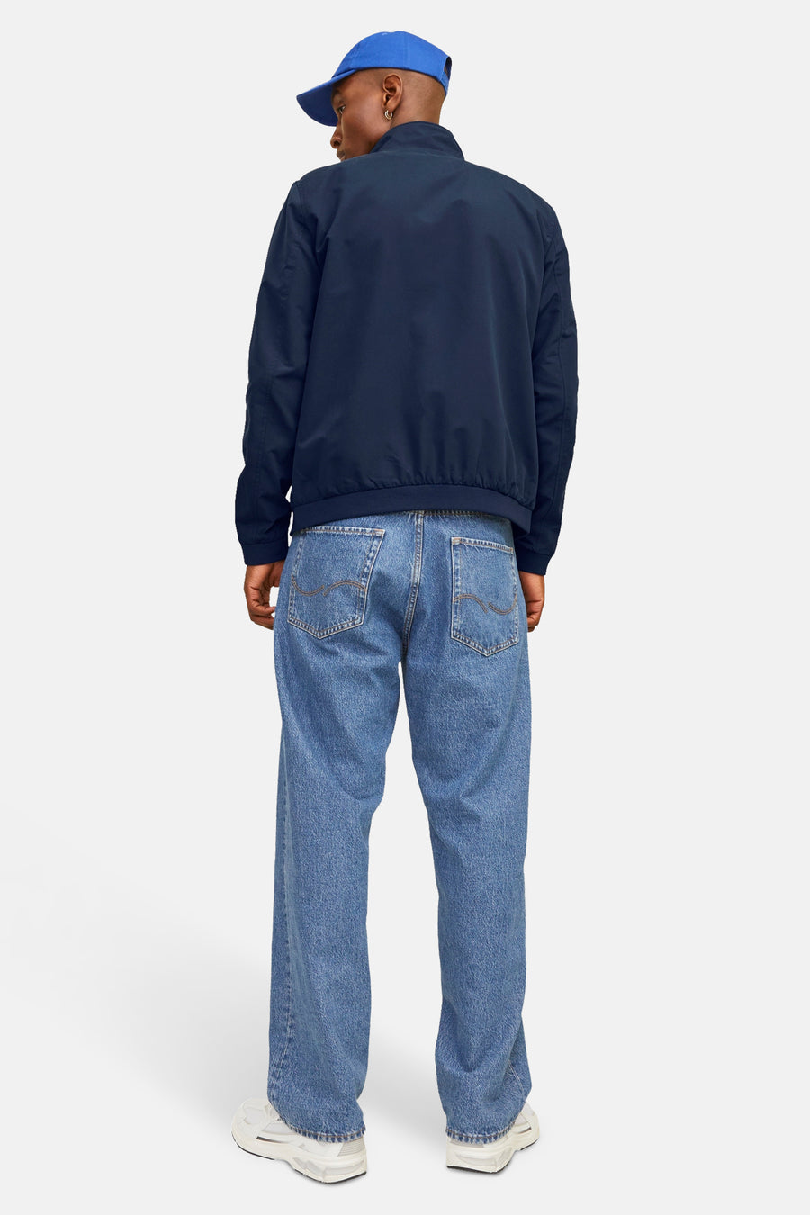 Korte blauwe jas van JACK & JONES, met wijde jeans en een blauwe pet