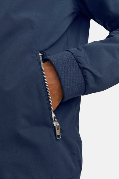 Korte blauwe jas van JACK & JONES, met een zilveren ritssluiting op de zak.
