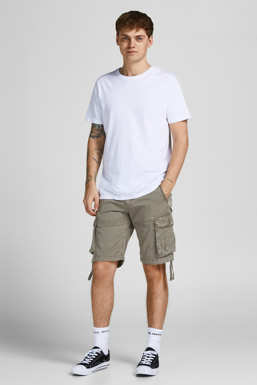 Korte groene cargo van JACK & JONES, gedragen met een effen wit T-shirt en zwarte lage sneakers.