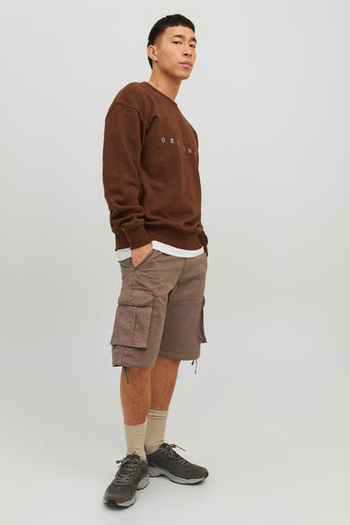 Short marron de JACK & JONES JEANS INTELLIGENCE, style cargo, porté avec un pull marron et des baskets.