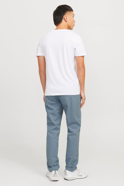 Chino bleu de JACK & JONES JEANS INTELLIGENCE, porté avec un t-shirt blanc uni et des baskets blanches.