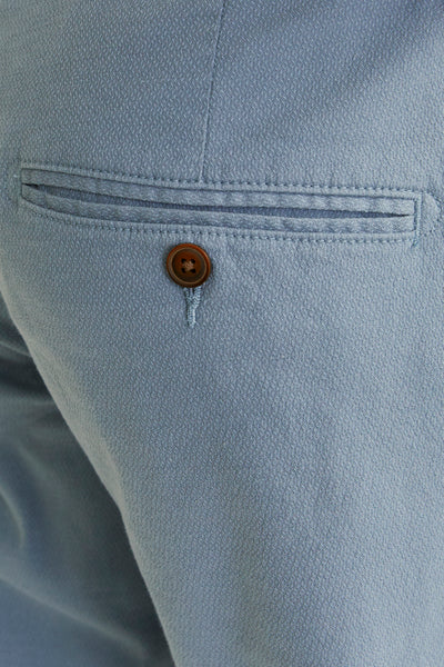 Blauwe chino van JACK & JONES JEANS INTELLIGENCE, met achterzak met knoopsluiting en subtiele textuur.