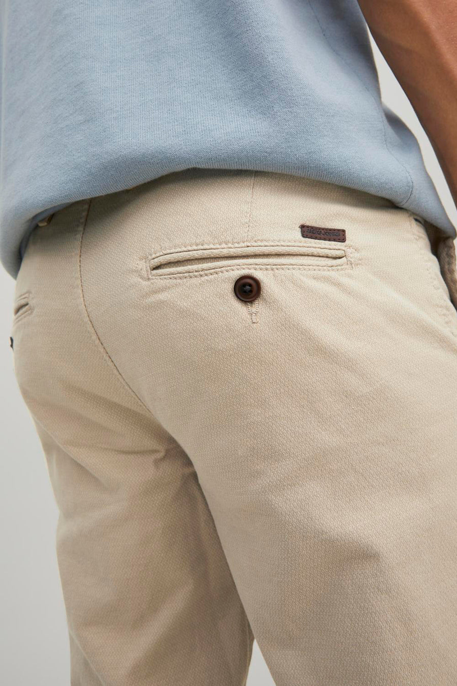 Chino beige de JACK & JONES, avec poche arrière boutonnée et étiquette de la marque.