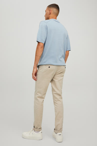 Chino beige de JACK & JONES JEANS INTELLIGENCE, porté avec un polo bleu clair et des baskets blanches.